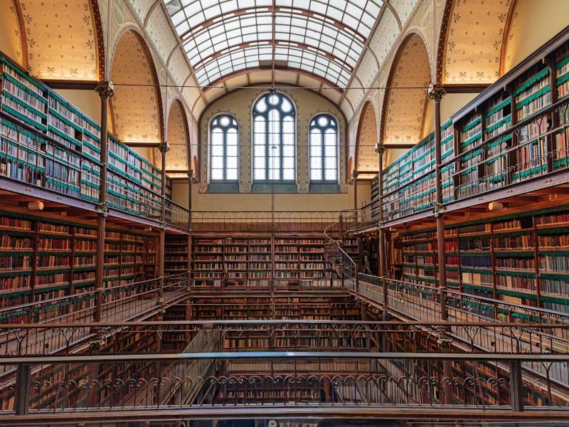 Grand library interior with tall bookshelves and arched windows
