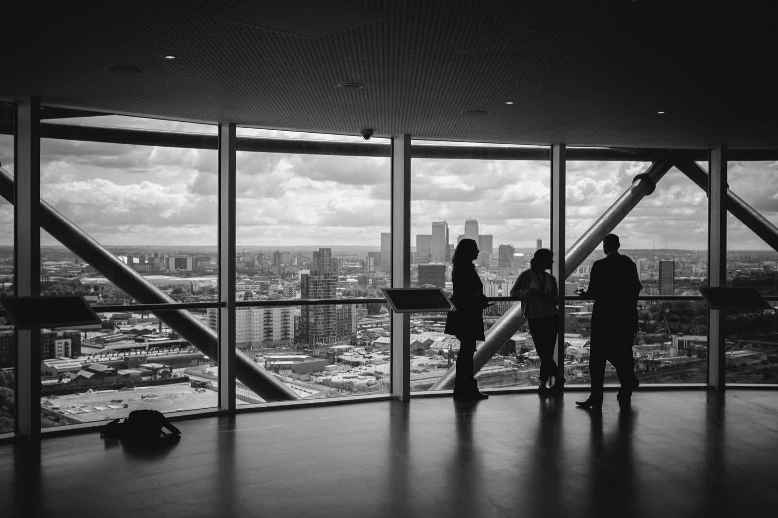 Professionals in conversation overlooking a city skyline
